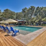 cedar pool deck with blue lounge chairs and umbrellas