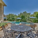 poolside dining area in back yard by swimming pool