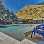 yellow umbrella with blue chairs by modern rectangle swimming pool