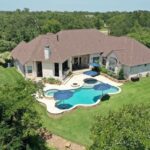 backyard overview with custom swimming pool and large home