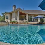 back patio living area by swimming pool with umbrellas