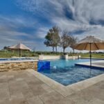 countryside outdoor swimming pool with umbrellas in brenham texas