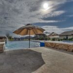 grey stone back patio area and swimming pool in texas countryside