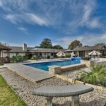 pea gravel outdoor area surrounding rectangular swimming pool and gazebo